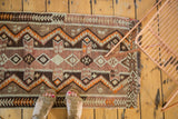 Vintage Turkish Kilim rug featuring geometric zigzag motifs in rich brown, tangerine, and ivory.