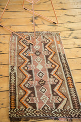 Hand woven Turkish Kilim rug corner, revealing brown, orange, ivory geometric zigzag.