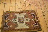Geometric pattern in sand hourglass motif with brown zigzag border on a vintage kilim.