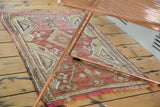 Vintage Kilim rug detail with madder root red, plum hues, floral motifs, and soft blush fringe.