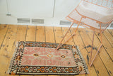 Vintage Kilim rug right corner with irregular weave, peach, tangerine, charcoal geometric patterns.