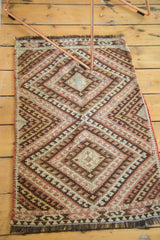 Fringed end of hand woven Turkish Kilim rug, showcasing diamond and zigzag patterns.