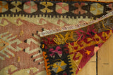 Detail of the fringed edge and vibrant hand-woven back of a Turkish Kilim rug.
