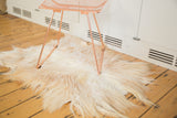 Ivory and reddish-brown texture of a luxurious angora skin rug's soft pile.