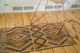 Paneled geometric pattern on a vintage Turkish Kilim rug, with brown, orange, and grey double medallions.
