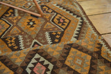 Vintage Turkish Kilim rug displaying geometric paneled patterns in brown, orange, and antique ivory.