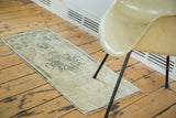 Secured fringed end of vintage Oushak runner with light sand field and charcoal zigzag border.