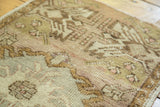 Vintage Oushak runner's textured pile showing mostly even distress and intricate green-mauve patterns.