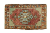 Vintage Oushak rug mat featuring an oversized stepped medallion in burgundy, celadon, and blue.