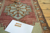 Geometric stepped medallion and border design on vintage Oushak rug in burgundy, celadon, and burnt orange.