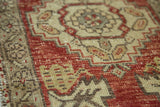 Decorative distressed Oushak runner pile, with cherry red and ivory stepped patterns.