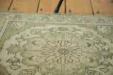 Muted earthen green and sand tones on the soft pile of this vintage Oushak rug.