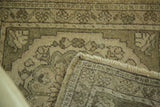 Hand-knotted foundation, fringe, and earthen green floral border of a vintage Oushak rug.