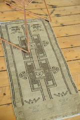 Geometric renderings in dark charcoal on sand and beige Oushak rug pile.