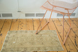 Geometric star medallions on a distressed light brown Oushak rug runner.