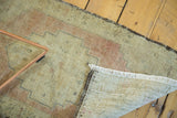Vintage Oushak runner's hand-knotted foundation, worn pile texture, and creamy fringe.