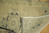 Hand-knotted Oushak rug pile with dark motifs, clean ivory fringe, and neatly bound side.