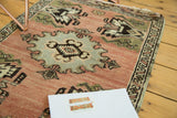 Hand-knotted vintage Oushak rug detail: blush field, slate blue medallion edge, and a green planter motif.