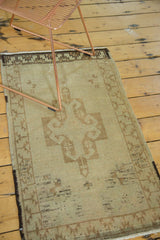 Detail of vintage Oushak rug: ornate beige medallion, brown rams horn, even pile wear.