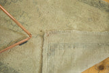 Vintage Oushak rug reverse, revealing irregular weave and sand foundation.