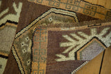 Vintage Oushak rug mat with irregular weave and geometric border patterns, brown, orange, ivory.