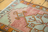 Hand-knotted vintage Oushak rug with faded cranberry, powder blue, tangerine geometric motifs.