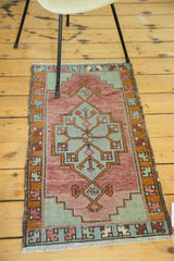 Hand-knotted vintage Oushak runner corner, showcasing faded cranberry, celadon geometric pattern, and fringe.