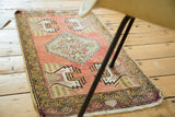 Peach pink vintage Oushak runner with stepped medallion and splayed floral motifs.