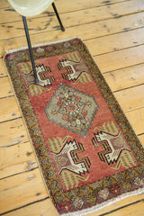 Vintage Oushak rug runner corner with peach pink field, splayed floral motif, and fringe.