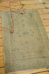 Distressed sand pile and secured, lightly reduced end of the vintage Oushak rug.