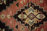 Hand-knotted Oushak rug detail showing stepped geometric motifs in rose, brown, cream, and blue.