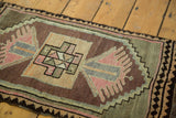 Geometric Oushak medallion and finned plant motifs in rose pink, apricot, and bronze.