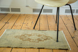 Hand-knotted pile featuring a pale bronze lozenge medallion on a vintage Oushak rug.