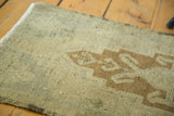 Close view of vintage Oushak rug's secured side, pale bronze palmette, and even pile wear.