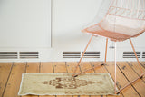 Vintage Oushak runner displaying a rectilinear medallion with rams horn motifs in beige and bronze.