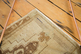 Vintage Oushak rug corner: beige and bronze rams horn pattern, even wear, secured side, small blue line.