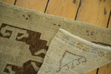 Hand-knotted corner detail of vintage Oushak rug, showing irregular pile and woven foundation.