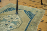 Oushak rug mat corner showing aqua blue geometric schools of fish motif on sand.
