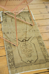 Vintage Oushak rug corner: pale ivory field with abrash, lower medallion, charcoal geometric border.