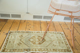 Vintage Oushak rug's floral medallion and meandering leaf motif in pale bronze and ivory.