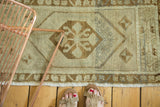 Vintage Oushak runner's secured fringe and geometric border in pale bronze, antique ivory.