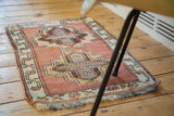 Hand-knotted vintage Oushak rug mat showing blush and raw copper geometric designs with fringe.