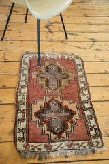 Vintage Oushak rug corner: blush, charcoal, raw copper geometric medallion, and secured fringe.