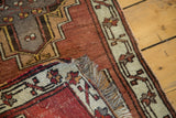 Hand-knotted Oushak rug corner with fringe and geometric ivory, copper, charcoal pattern.
