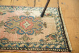 Hand knotted Oushak rug corner, low pile, apricot blush, blue, green meandering leaf border, fringe.