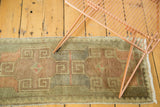 Vintage Oushak runner's scrolling rams horn design in bronze, peach, and sage green.
