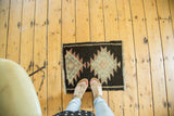 Hand-knotted Oushak rug's serrated double medallion in charcoal, faded blush, and ivory.