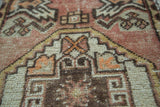 Serrated geometric pattern detail on vintage Oushak rug, showing distressed blush and bronze pile.