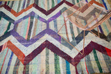 Dense hand woven vintage rag rug with vibrant chevron and stripe patterns.