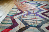 Vibrant geometric chevron pattern in violet, red, and ivory on this vintage rag rug.